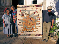 Zapotec mezcal makers showing off a blanket with Mayahuel woven into it